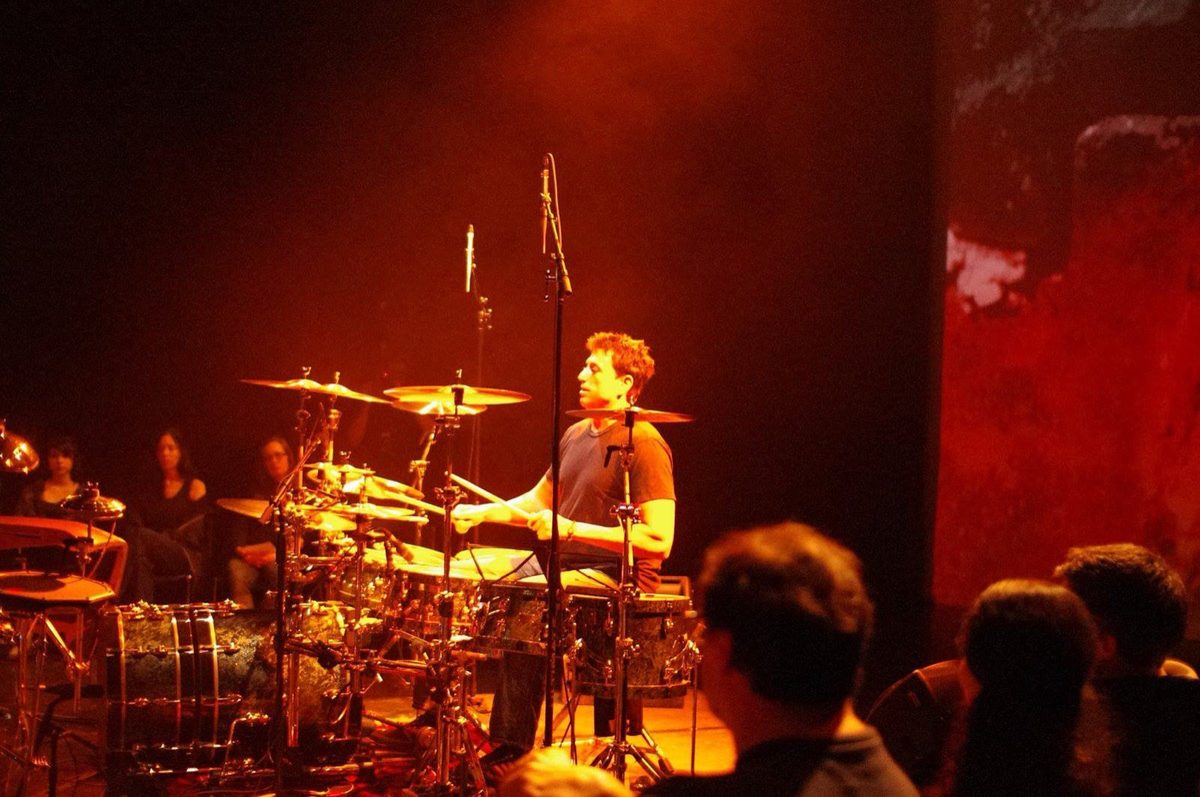 Steve Joslin at the drum kit with projected visuals behind him